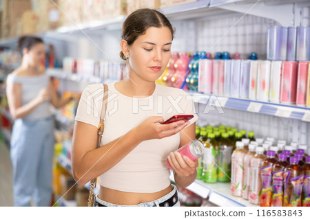 Woman looking for soda from photo on internet 116583843