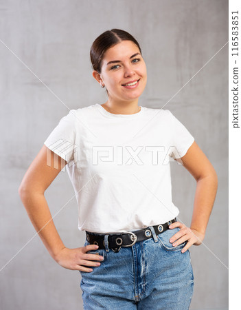 Cheery young woman posing happily against gray background 116583851