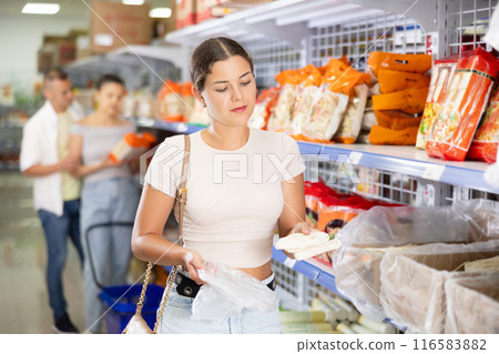 Young woman choosing noodles in store Young woman choosing noodles in store 116583882