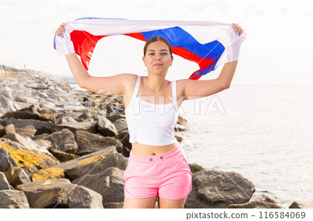 National flag of Russia. Beautiful woman with Russia flag on beach. 116584069