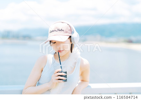 女人在戶外聽音樂時喝冰咖啡 116584714
