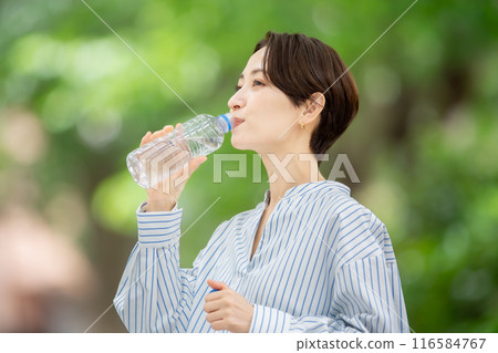 拿著塑膠瓶的女人，新鮮的綠色植物 116584767