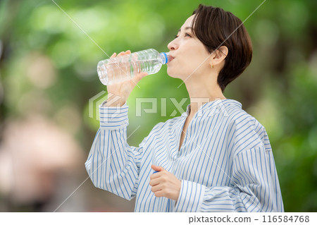 拿著塑膠瓶的女人，新鮮的綠色植物 116584768