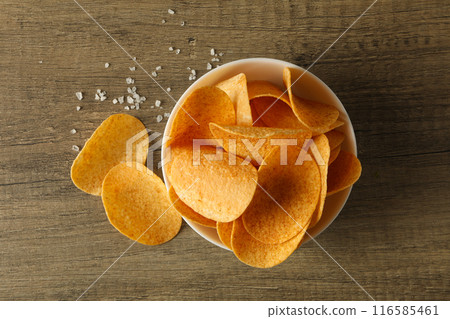 Potato chips in a bowl on a wooden background 116585461