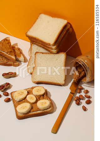 Peanut paste in a glass jar with toast, on a light background. 116585534