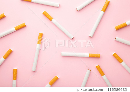 Many cigarettes on pink background. Top view. Many cigarettes on pink background. Top view. 116586683