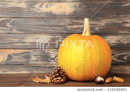 Autumn pumpkins with autumn harvest on brown wooden background Autumn pumpkins with autumn harvest on brown wooden background 116586941