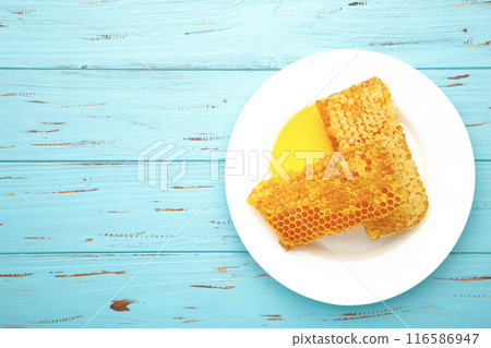 Sweet honeycomb on blue background. Top view 116586947