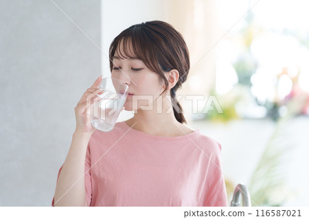 Young woman drinking water 116587021