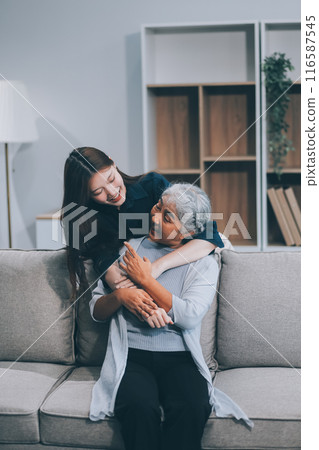 Adult daughter old mom hugging sit on couch enjoy pleasant positive talk, remembering funny occasion from life spend weekend together, caring about older generation relatives express attention concept 116587545