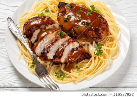 Chicken Lazone with sauce and linguine on plate 116587928
