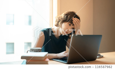A woman worried while using a computer A woman worried while using a computer 116587982