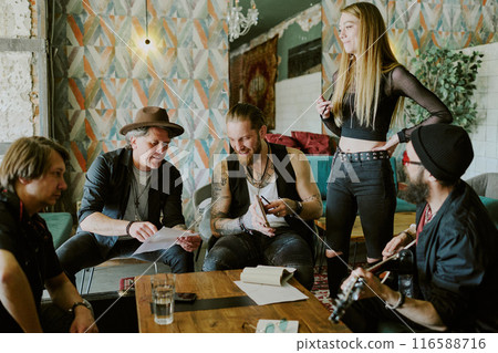 Group of gen X and gen Y musicians spending time in abandoned house working together on rock music album Group of gen X and gen Y musicians spending time in abandoned house working together on rock music album 116588716