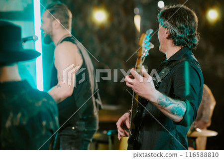 Group of unrecognizable rock musicians enjoying playing song on stage in nightclub, selective focus shot 116588810