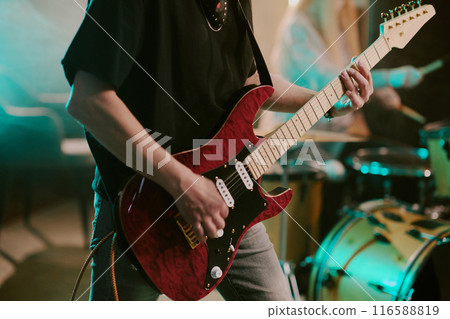 Unrecognizable punk rock musician playing electric guitar in band on stage, medium section shot Unrecognizable punk rock musician playing electric guitar in band on stage, medium section shot 116588819