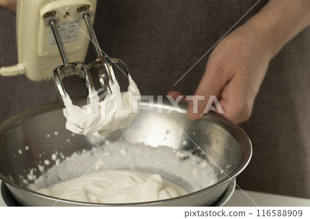 Whip the cream using a hand mixer Whip the cream using a hand mixer 116588909