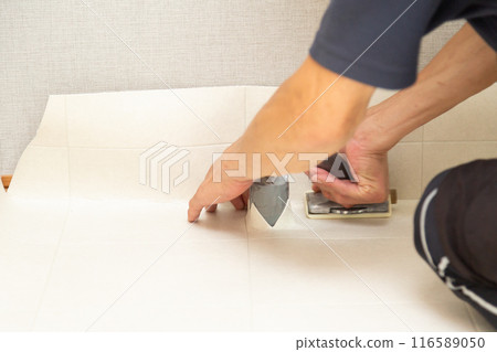 在舊房屋翻新過程中，布藝工匠將地磚貼在水域地板上。 116589050