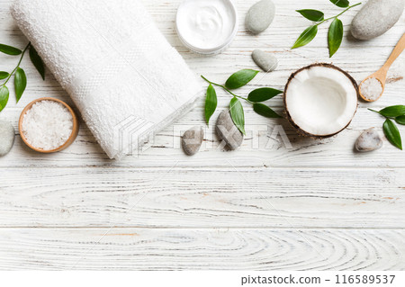 Coconut with jars of coconut oil and cosmetic cream on colored background. Top view. Free space for your text. Natural spa coconut cosmetics and organic treatment concept Coconut Spa composition 116589537