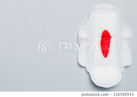 Women hygiene products or Sanitary pad with red feather on colored background. Pastel color. Closeup. Empty place for text. Female daily hygiene 116589543