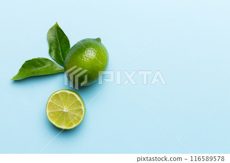 Lime fruits with green leaf and cut in half slice isolated on white background. Top view. Flat lay with copy space Lime fruits with green leaf and cut in half slice isolated on white background. Top view. Flat lay with copy space 116589578