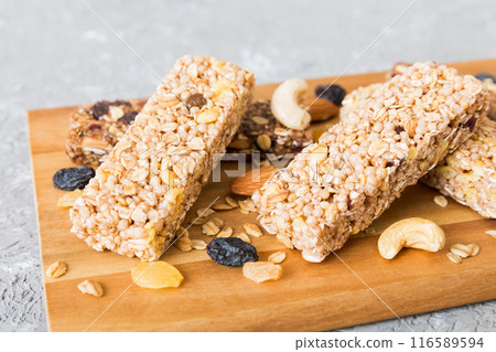 Various granola bars on table background. Cereal granola bars. Superfood breakfast bars with oats, nuts and berries, close up. Superfood concept 116589594