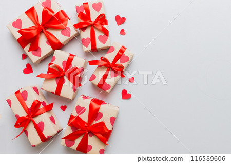 Top view photo of valentine day decorations gift box with red ribbon bow on colored background. Holiday gift boxes with top view 116589606