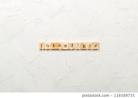 intangible word written on wood block. intangible text on cement table for your desing, concept intangible word written on wood block. intangible text on cement table for your desing, concept 116589735