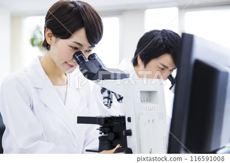A researcher conducting an experiment in a laboratory A researcher conducting an experiment in a laboratory 116591008