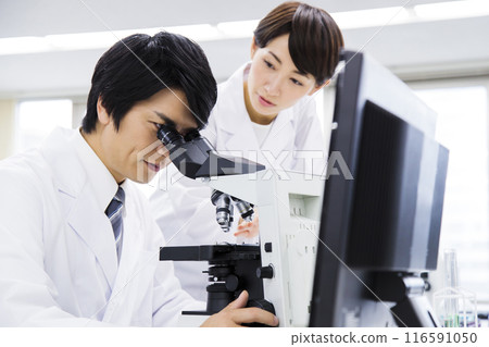 A researcher conducting an experiment in a laboratory A researcher conducting an experiment in a laboratory 116591050