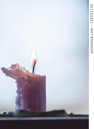 Burning candle on a white background. Shallow depth of field. 116591139