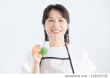 女人喝綠汁，看相機，保健食品的圖像等。 116591576