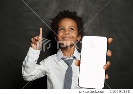 Joyful little school boy holding cell phone in his hand presenting smartphone empty screen display Joyful little school boy holding cell phone in his hand presenting smartphone empty screen display 116591588