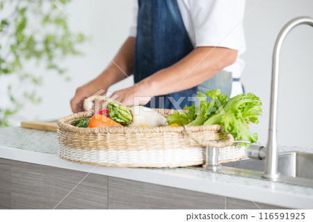 A man's hands cutting vegetables, close-up, no face 116591925