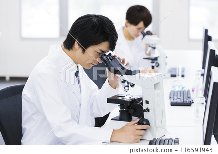 A researcher conducting an experiment in a laboratory 116591943