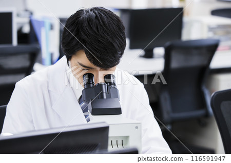 A researcher conducting an experiment in a laboratory 116591947