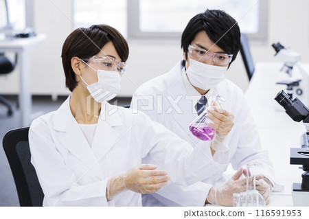 A researcher conducting an experiment in a laboratory 116591953