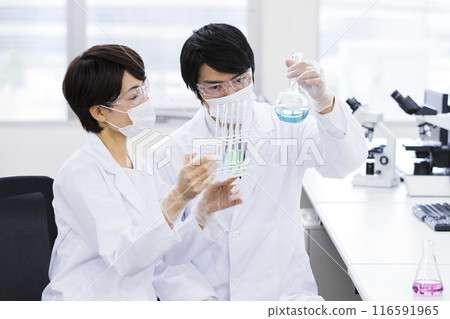 A researcher conducting an experiment in a laboratory 116591965
