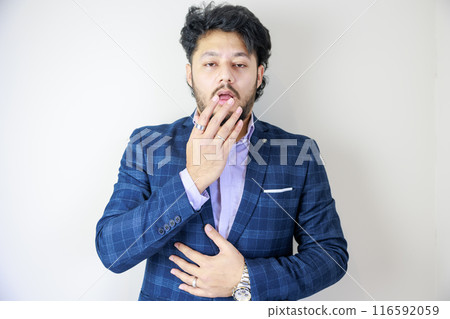 A businessman hiding his mouth with a surprised expression A businessman hiding his mouth with a surprised expression 116592059