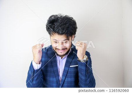 Handsome man doing a cheering fist pump Handsome man doing a cheering fist pump 116592060