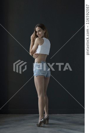 young beautiful woman on a dark background, full length studio shot young beautiful woman on a dark background, full length studio shot 116592087