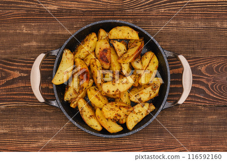 Potato wedges roasted in oven with thyme and salt 116592160