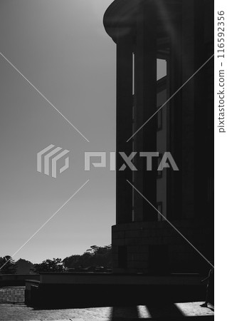 In front of a building, there is a black and white photo of a statue In front of a building, there is a black and white photo of a statue 116592356