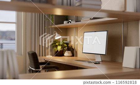 A computer with a white-screen mockup on a wooden desk in a cozy home office. A computer with a white-screen mockup on a wooden desk in a cozy home office. 116592818