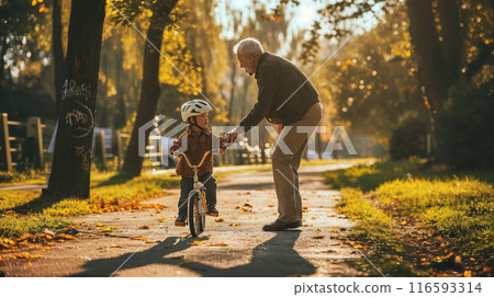 grandfather teaches grandson to ride a bike grandfather teaches grandson to ride a bike 116593314