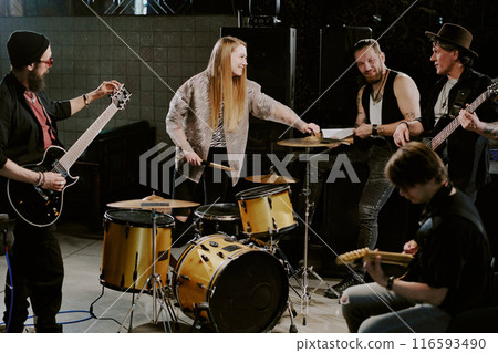 Wide shot of modern alternative rock band getting ready for rehearsal or performance 116593490