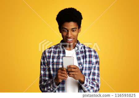 Cool Application. Interested Guy Using Smartphone on Yellow Background Cool Application. Interested Guy Using Smartphone on Yellow Background 116593825