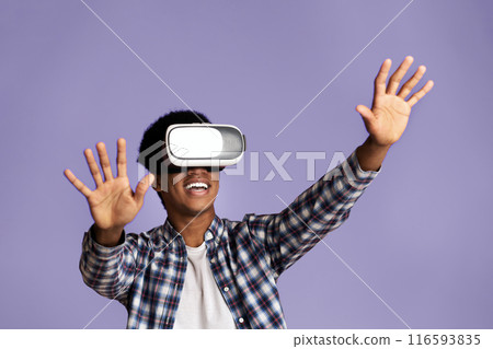 Happy teen guy enjoying virtual reality glasses experience, modern entertainment, pink studio background 116593835