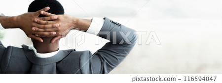 Back view of african american businessman leaning back, resting over white wall background, panorama with copy space 116594047