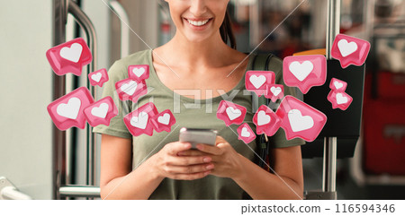 A woman smiles as she uses her smartphone on a public bus. Surrounding her are various heart icons in a pink hue, resembling social media notifications A woman smiles as she uses her smartphone on a public bus. Surrounding her are various heart icons in a pink hue, resembling social media notifications 116594346