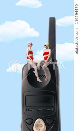 Contemporary art collage. Two friends in red swimsuits sit atop vintage phone, enjoying sunny sky, ready for moment to dive into relaxation and fun. 116594470